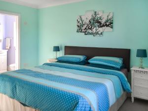 a blue bedroom with a bed with two blue pillows at Pondside in Boston