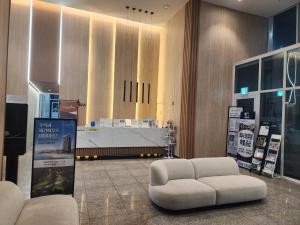 un vestíbulo con una silla blanca y una mesa en Sokcho Summitbay 1807 "Ocean View", en Sokcho