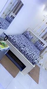 łóżko z czarno-białą pościelą i poduszkami w obiekcie Jacetnouche w mieście Dakar