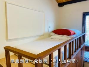 台南的住宿－捉鳳凰 台南百年老宅包棟導覽民宿系列Catchphoenix Centennial Guesthouse，客房配有带红色枕头的双层床。