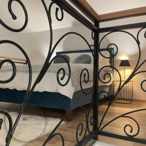 - une chambre avec un lit et un portail en fer forgé dans l'établissement Villa Countryside Vrsac, à Vršac
