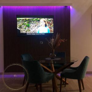 a dining room with a table and a tv with purple lighting at Villa Countryside Vrsac in Vršac