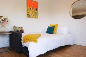Un dormitorio con una cama blanca con una manta amarilla. en Modern one Bedroom Apartment in Ealing Common en Londres