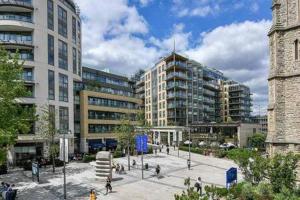 a group of people walking in a city with buildings at Spacious Apartment In The Heart Of Ealing Broadway in London