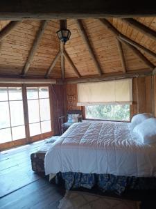 1 dormitorio con 1 cama grande en una habitación con ventanas en el portal de zapallar ,laguna de zapallar maitencillo, en Zapallar