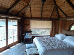 1 dormitorio con 1 cama en una habitación con ventanas en el portal de zapallar ,laguna de zapallar maitencillo, en Zapallar