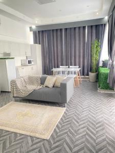 un salon avec un canapé et une cuisine dans l'établissement Al Hussam Hotel Apartments, à Mascate