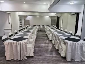 a room with rows of tables and chairs in it at Al Hussam Hotel Apartments in Muscat