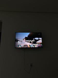 TV de pantalla plana colgada en la pared en Pousada Flor de Laranjeira, en Lençóis