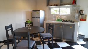 a small kitchen with a table and a refrigerator at Puesta del Sol Apart in Puerto Iguazú