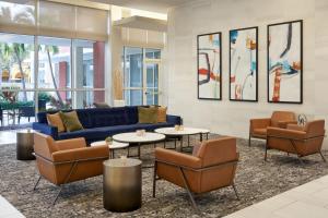 a lobby with a blue couch and chairs and tables at Residence Inn by Marriott West Palm Beach Downtown in West Palm Beach