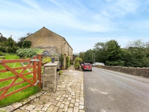 Luddenden FootにあるVintage Cottageの道路脇に停車した赤い車