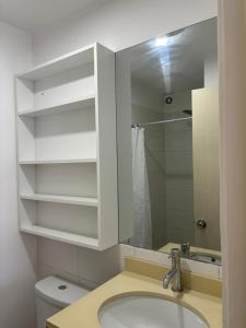 y baño con lavabo y espejo. en Imagine Apartment, en Lima