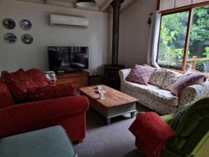 uma sala de estar com dois sofás e uma mesa de centro em Lark Cottage em Burrawang