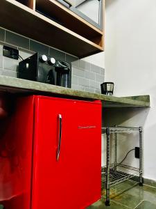 a red cabinet in the middle of a kitchen at Flat -Hidromassagem privativa e Piscina a 500 mts da praia in São Vicente
