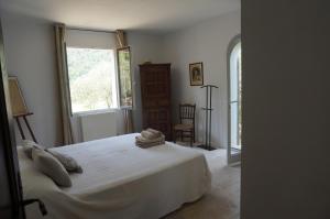 a bedroom with a white bed and a window at L'arcadie Du Souleyan in Oppède