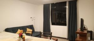 Monoambiente acogedor, cómodo e iluminado في لاباز: غرفة معيشة مع طاولة وأريكة وتلفزيون