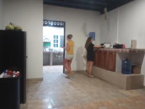 dos mujeres de pie en una cocina preparando comida en Ferdinand the bull hostel en Pedasí Town