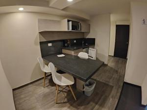 a kitchen with a table and chairs in a room at Kasa Hotel & Suites in Irapuato