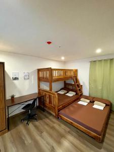 a bedroom with two bunk beds and a desk at CASA JBL Megatower 4 in Baguio