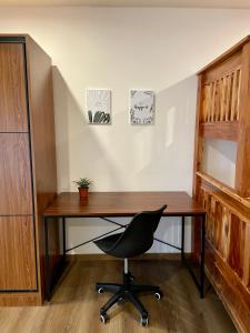 a desk with a black chair and a wooden table at CASA JBL Megatower 4 in Baguio