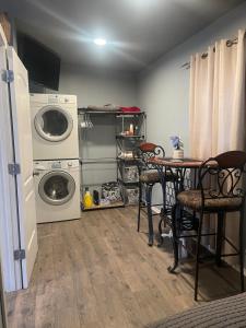 eine Waschküche mit einem Tisch, einer Waschmaschine und einem Trockner in der Unterkunft Man cave apartment in Athens