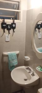 a bathroom with a white sink and a mirror at La Candelaria in La Punta
