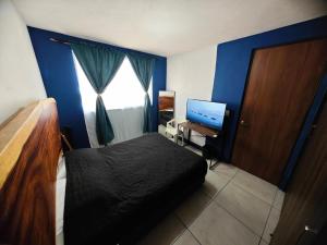 1 dormitorio con 1 cama y escritorio con ordenador en "Paco's Depa" Habitación privada en Depa compartido en el Centro Histórico con alberca y gimnasio!, en Guadalajara