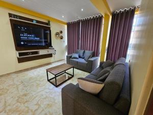 a living room with a couch and a flat screen tv at Departamento en Huanchaco Beach in Huanchaco