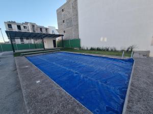 uma lona azul está no chão ao lado de um edifício em Departamento con Alberca San Jose em Querétaro