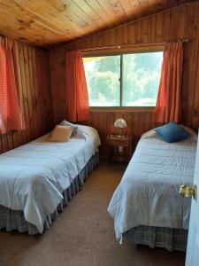 two beds in a room with two windows at Paine - Hermosa Parcela de Agrado in Santiago