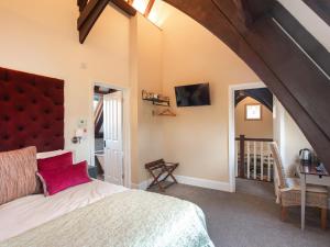 een slaapkamer met een groot bed met een rood hoofdeinde bij The Old School House 1-uk32061 in Burwarton