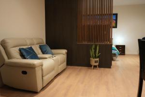 a living room with a white couch and blue pillows at Monoambiente de Lujo Cores in Cochabamba