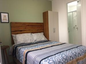 una camera con un grande letto con testiera in legno di Excelente Oportunidade! Acomoda até 4 pessoas! a San Paolo