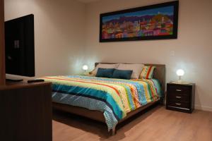 a bedroom with a bed and a flat screen tv at Monoambiente de Lujo Cores in Cochabamba