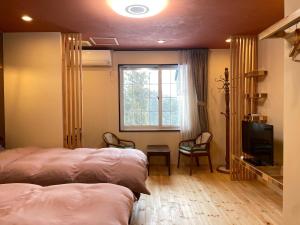 a bedroom with two beds and a tv and a window at Koguriyama Sanso - Vacation STAY 37447v in Minami Uonuma
