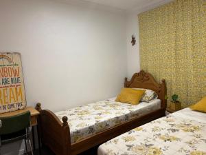 Parua Bay的住宿－Jordan Place，一间卧室配有两张单人床、一张桌子和一张床架