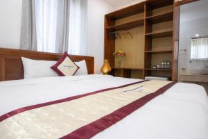 1 dormitorio con 1 cama grande con sábanas blancas en Hung Vuong Resort, en Phu Quoc