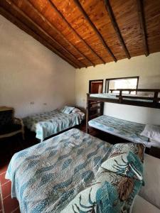two beds in a room with two bunk beds at Finca Hacienda Casa Prada in Bucaramanga