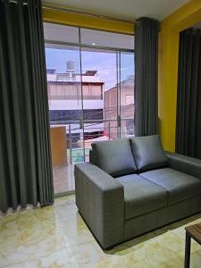 a living room with a couch and a large window at Departamento en Huanchaco Beach in Huanchaco