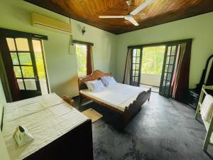 1 Schlafzimmer mit 2 Betten in einem Zimmer mit Fenstern in der Unterkunft Galle Side HomeStay in Galle