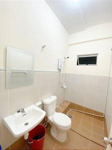 een badkamer met een wit toilet en een wastafel bij Sea view apartment level 21, sunrise view in Sandakan