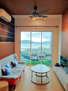 een woonkamer met een bank en een tafel bij Sea view apartment level 21, sunrise view in Sandakan