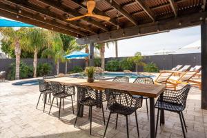 un patio con tavolo e sedie in legno e una piscina di The Olive a Phoenix