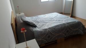 Un dormitorio con una cama con una manta. en Depto elegante y cómodo centro historico, en Quito