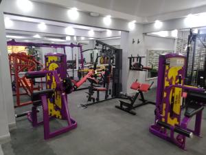 a gym with several treadmills and machines at Al Hussam Hotel Apartments in Muscat