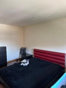een slaapkamer met een groot bed met een rood hoofdeinde bij Duplex/ T4 Quinta do Rei in Bragança