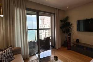 a living room with a large window and a television at Marina Urban Sea View - By AppartAli in Casablanca