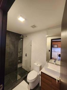a bathroom with a toilet and a shower and a sink at Eon-ClarionSuites Apart-estudio zona 10 con AC in Guatemala