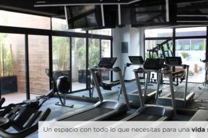a gym with several treadmills and two tables with laptops at Eon-ClarionSuites Apart-estudio zona 10 con AC in Guatemala